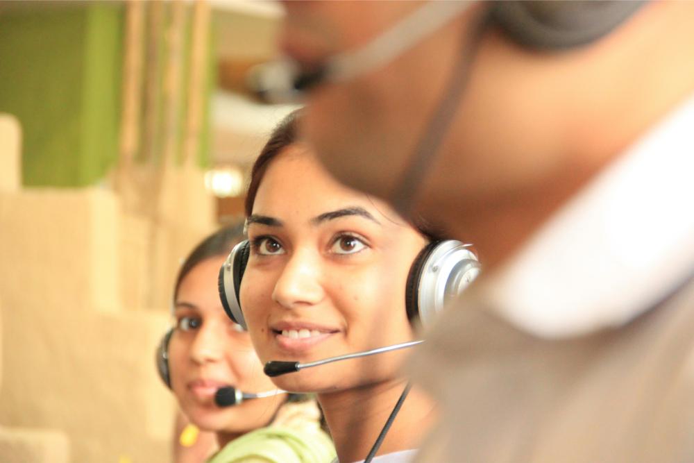 Woman with headset smiling at work