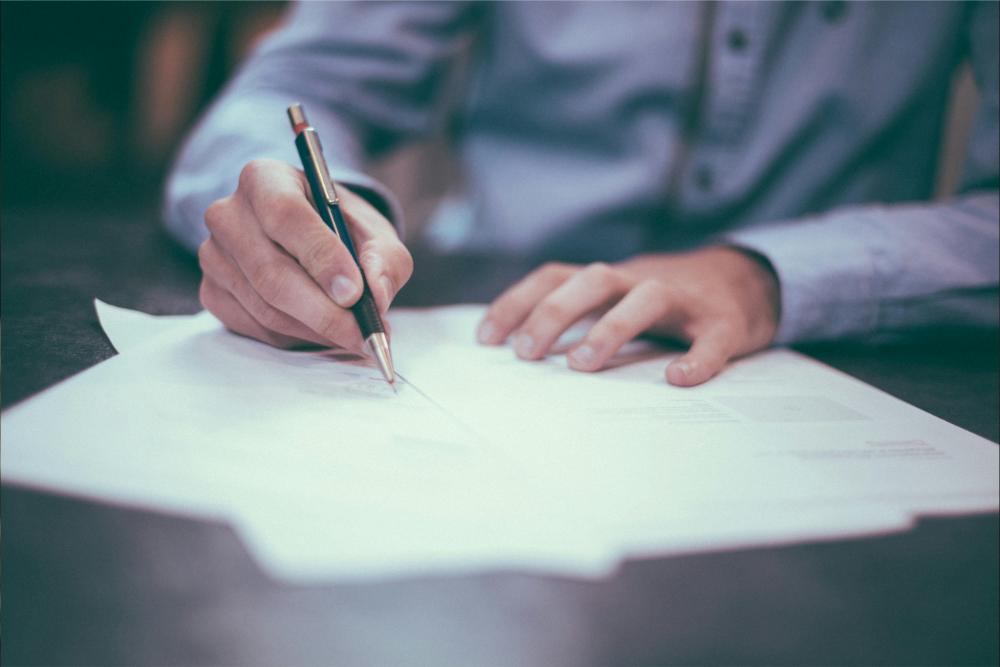 Man writing on paper at desk